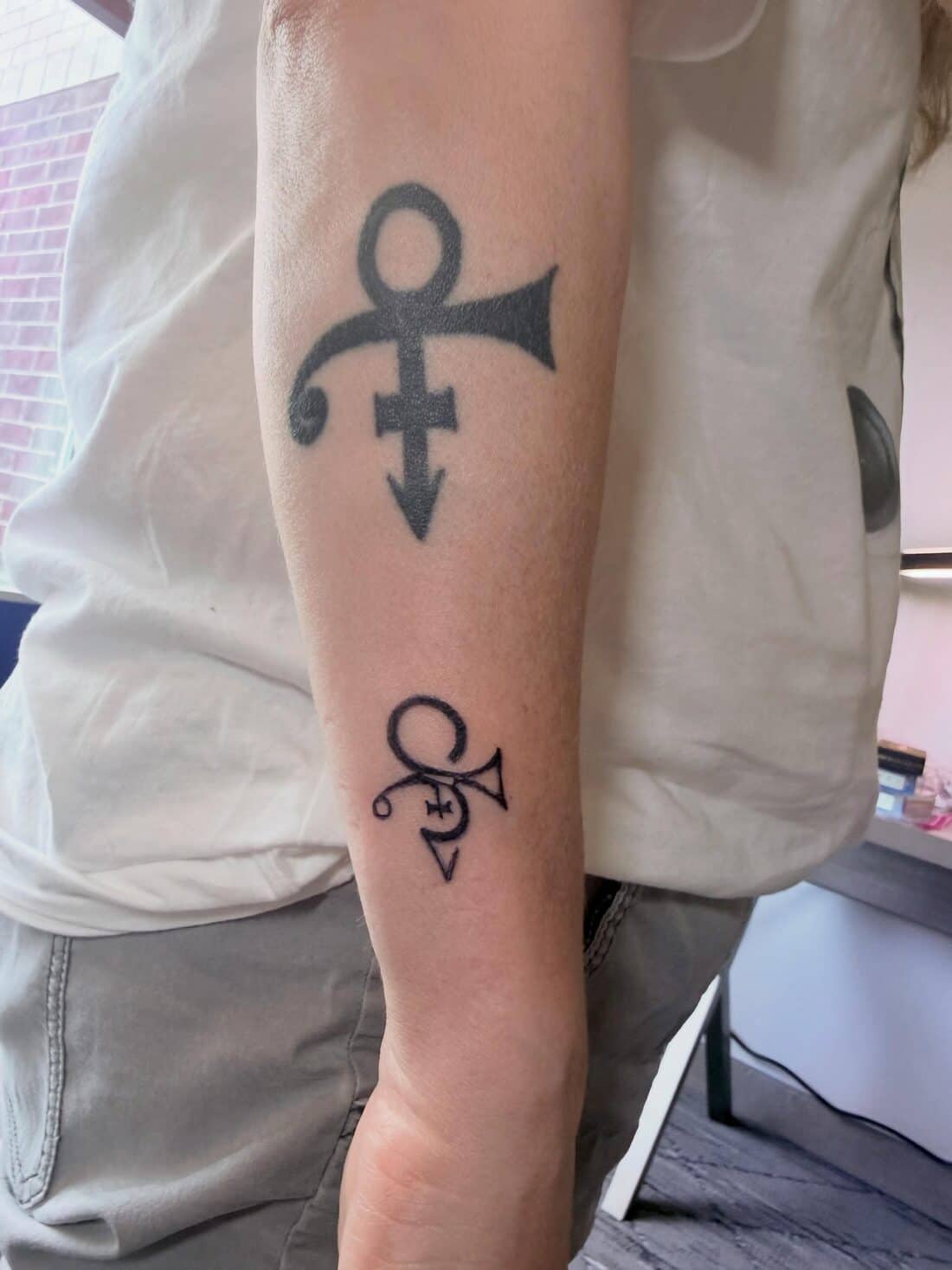 Tattoo by Apollonia Ink in Barrie, Prince love symbol on an upper arm