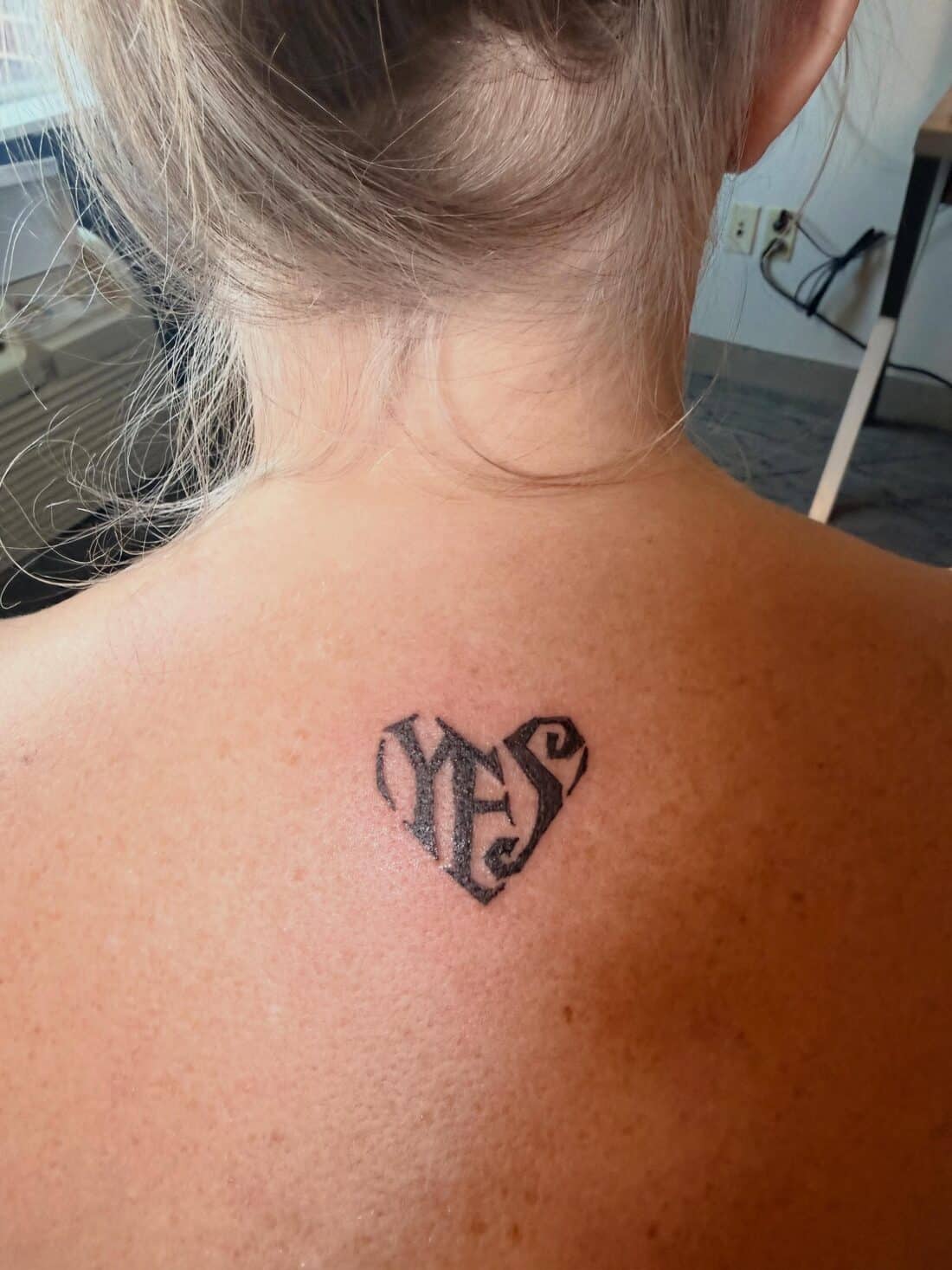 Tattoo by Apollonia Ink in Barrie, heart filled with YES lettering at the back of the neck