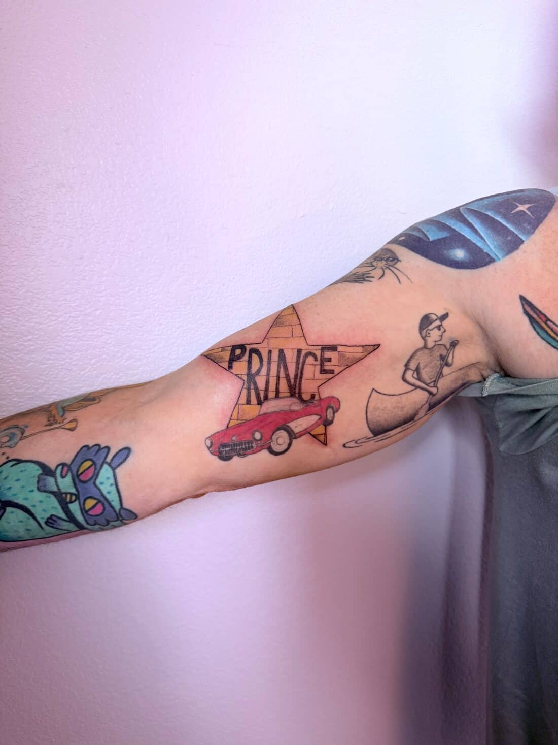 Tattoo by Apollonia Ink in Barrie, Prince sleeve on a forearm, with a star, lettering and a red car